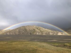 Ein Regenbogen spannt sich über die Berge des Jurtenlagers Köl-Suu in Kirgisistan.