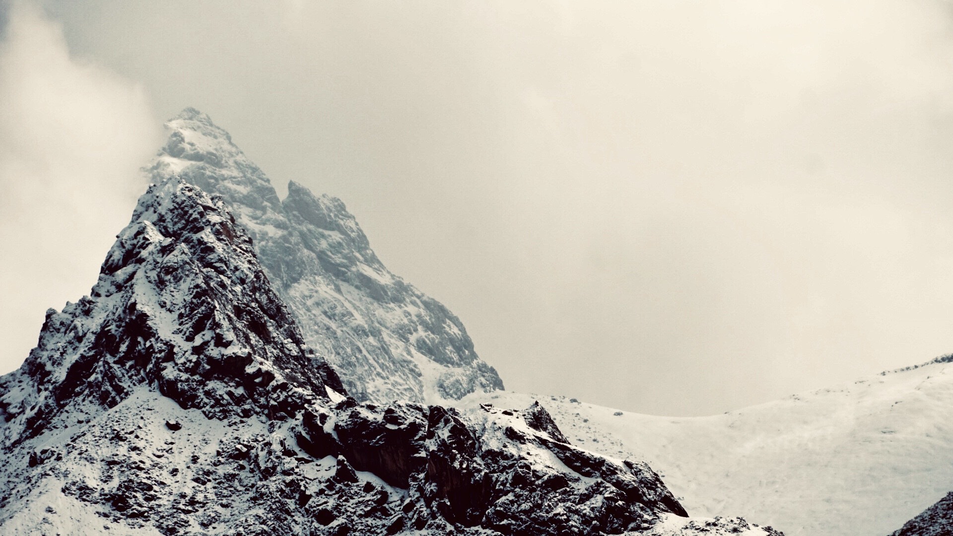 schneebedeckte Bergspitze grauer Himmel Wind