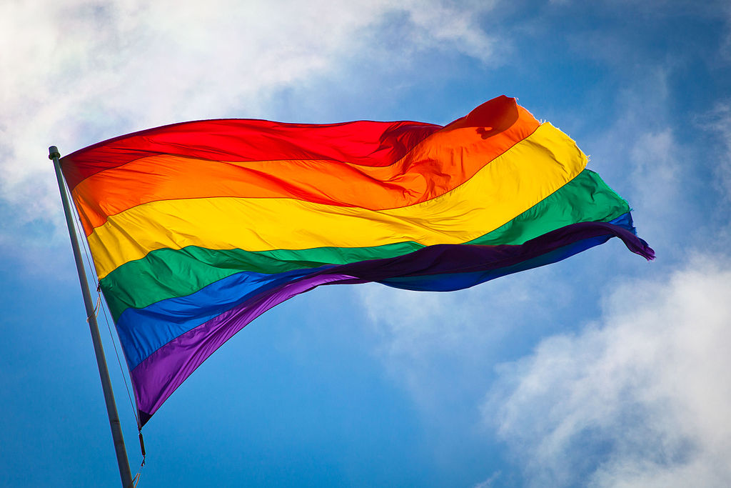 Rainbow flag against a blue sky