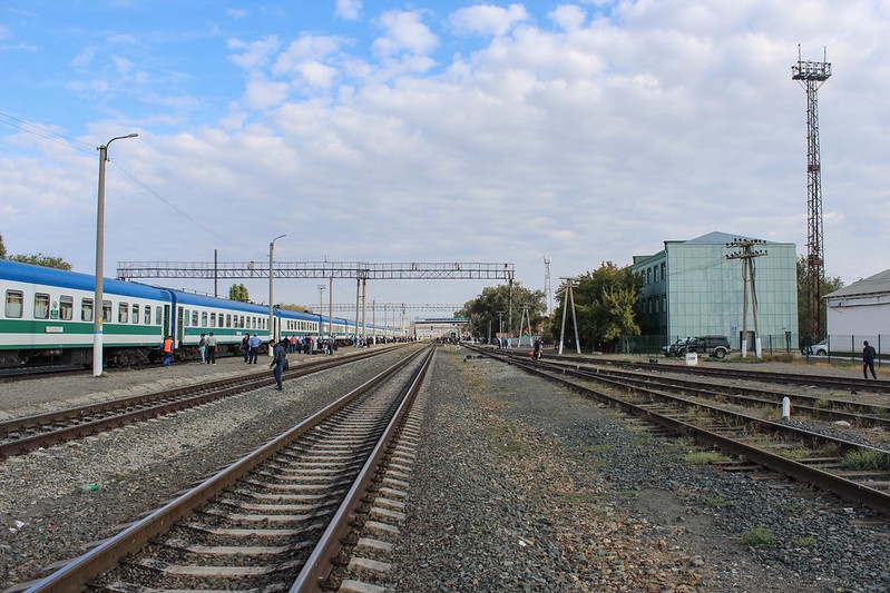 Railroads at a station in Uzbekistan. There is a blue, white and green train on the left.