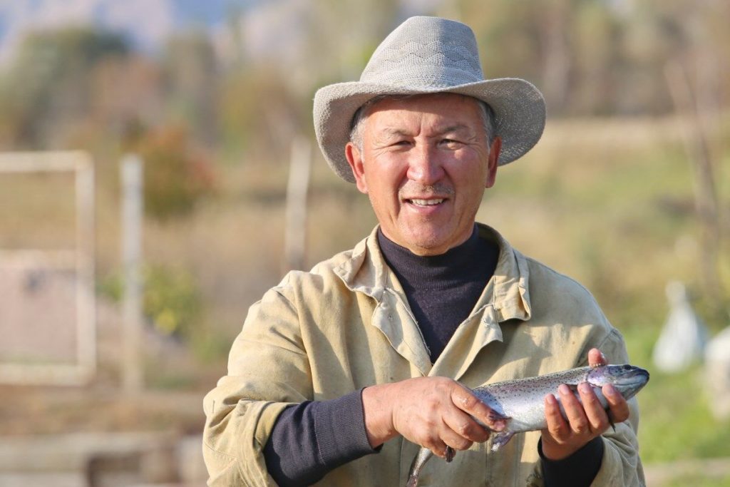 Musa Borbiev, a Kyrgyz man, holds a fish.