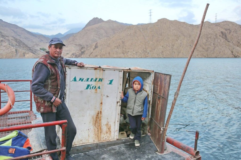 Sonunbek Kadyrov and his son on their ferry on the Naryn River