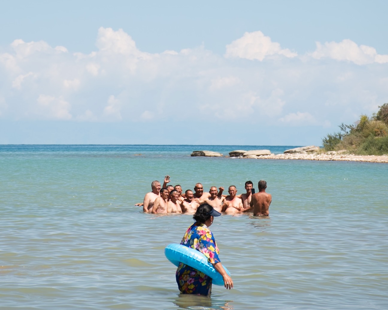 A woman and old men bath in the Issyk-Kul.