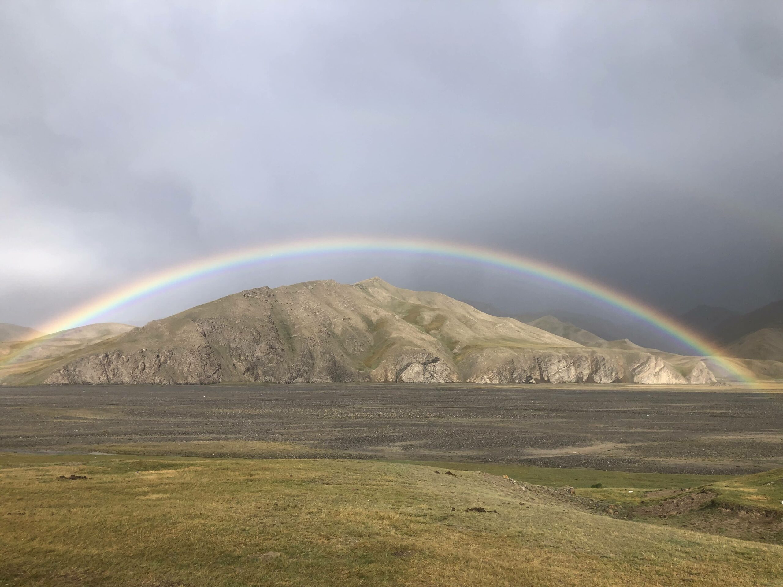 A rainbow stretches over the mountains of the Köl-Suu yurt camp in Kyrgyzstan.