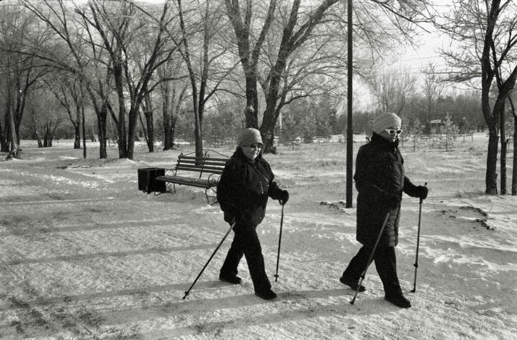 women coats snow park sticks trees