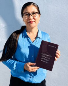 Linguist and translator Mahabat Sadyrbek with her English-language textbook, Comprehensive Grammar of the Kyrgyz Language. Photo courtesy of Mahabat Sadyrbek.