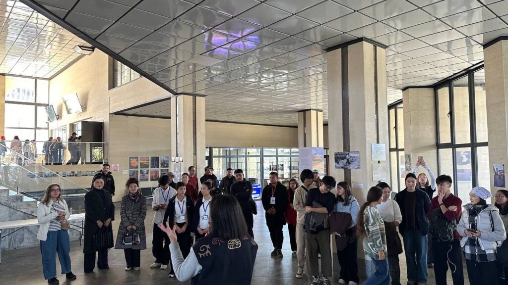 Visitors gather at Karakol Bus Station for Kyrgyzstan Beyond the Postcard, an exhibition showcasing everyday life through the eyes of amateur photographers. Courtesy of Peshcom / Street Gudit.