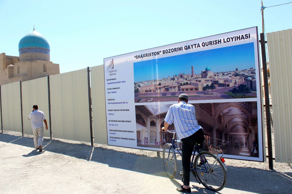 Un homme à vélo contemple le projet de centre commercial dans le centre historique de Boukhara