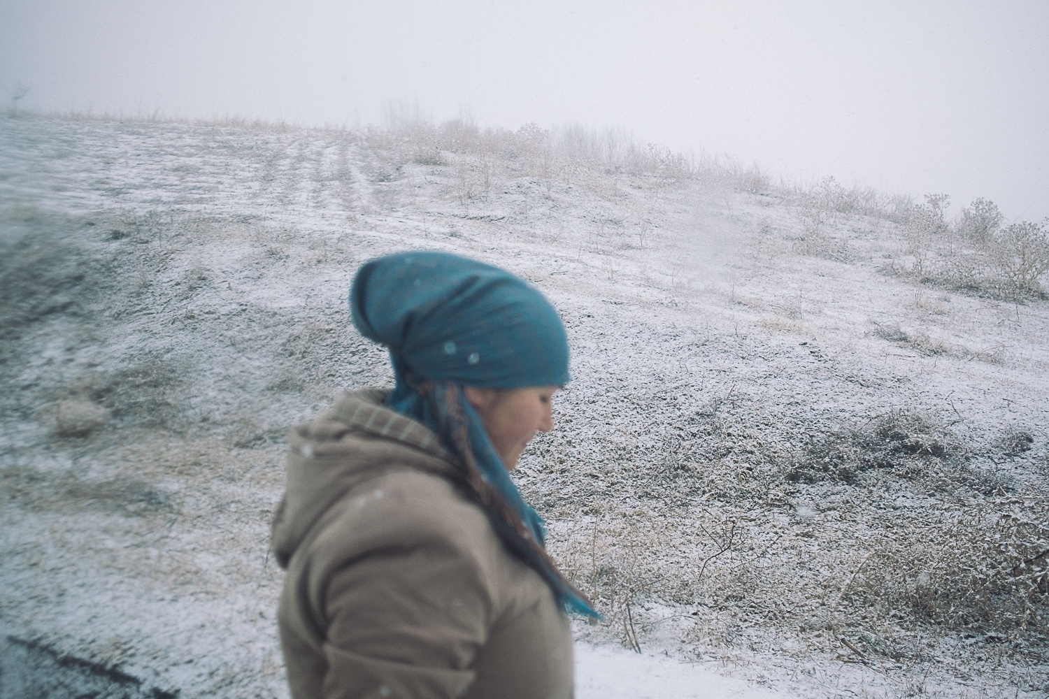 Une femme descendant du minibus dans l'hiver kirghiz, près de Mailuu-Suu au Kirghizstan