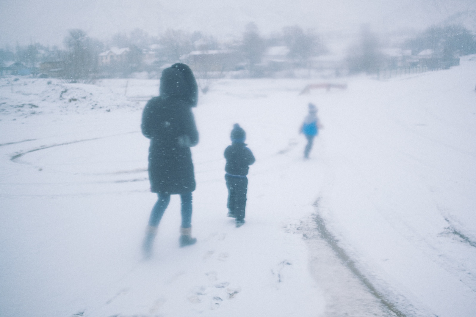 Une femme descend d'un minibus avec ses enfants au coeur de l'hiver kirghize,