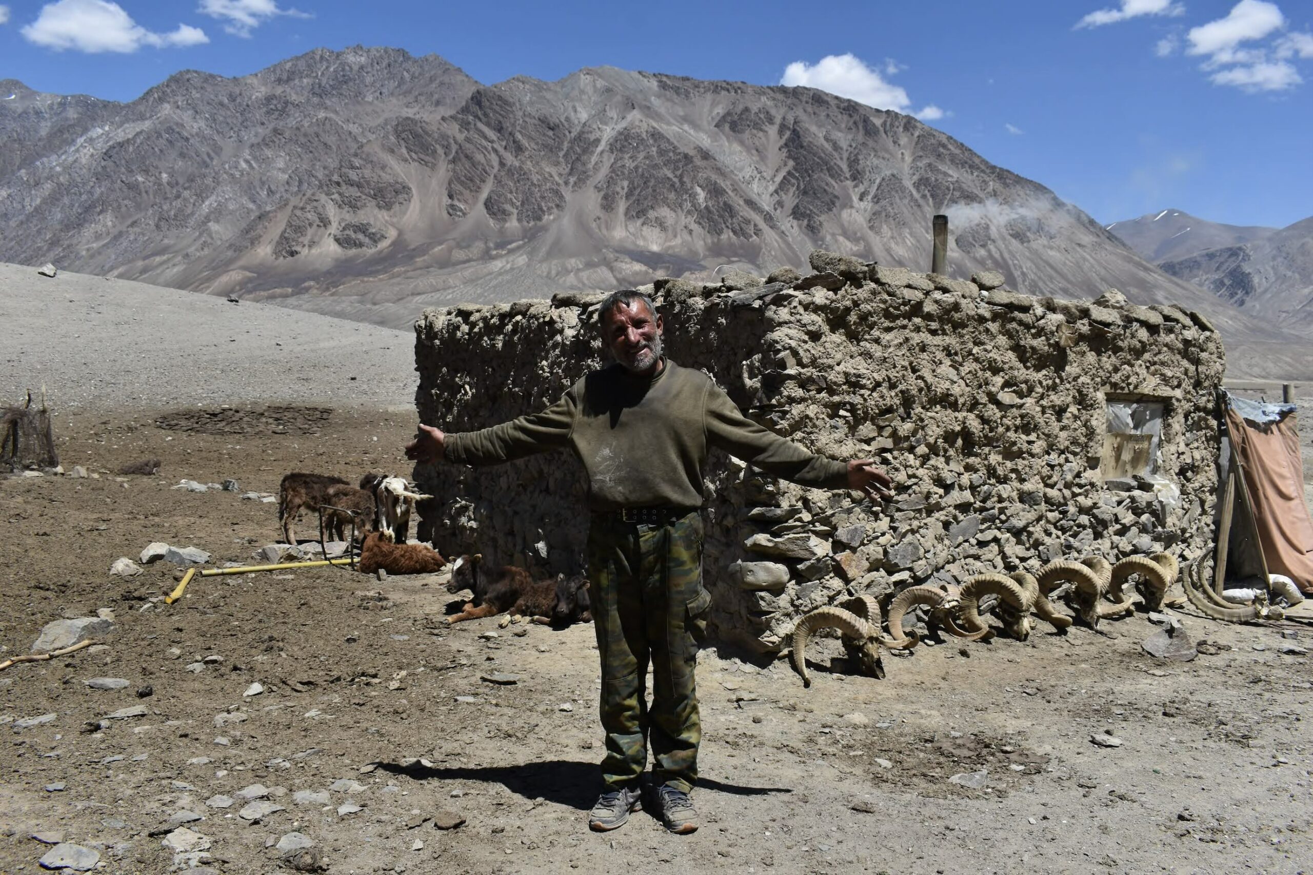 Maqsud, un berger tadjik dans le Gorno-Badachshan, à côté de cornes du mouton de Marco Polo.