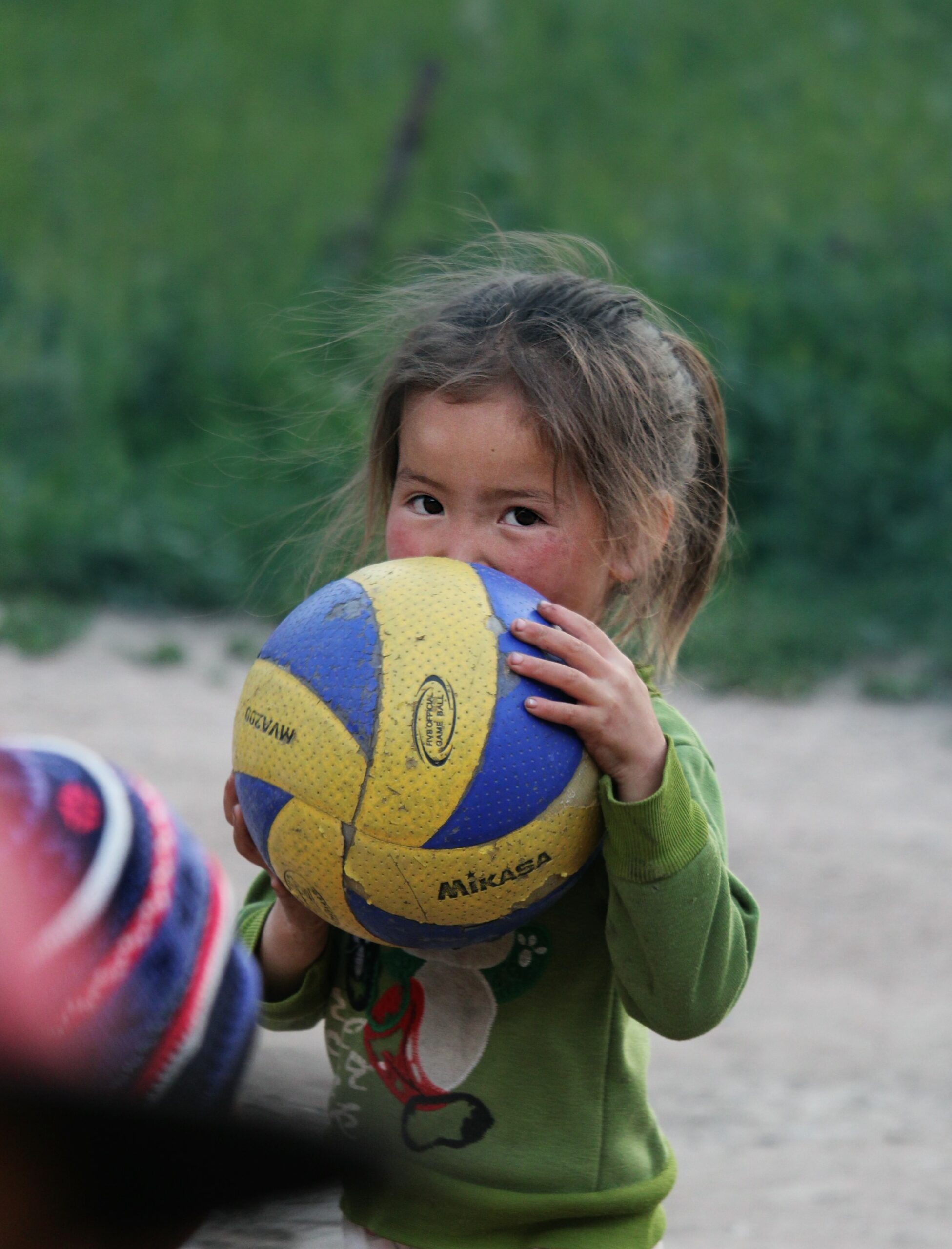 petite fille cachée derrière un ballon