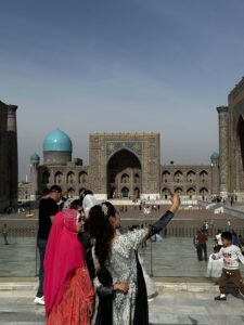 deux femmes registan samarcande téléphone selfie rouge