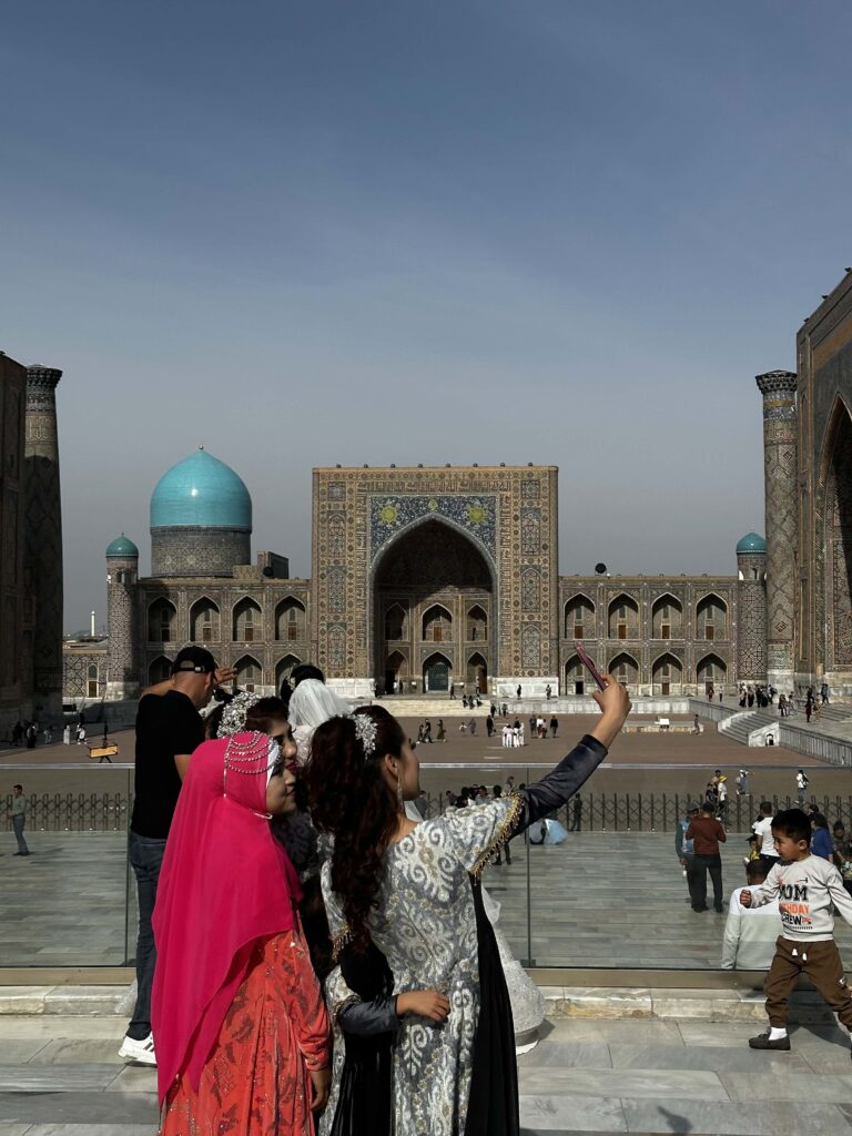 deux femmes registan samarcande téléphone selfie rouge